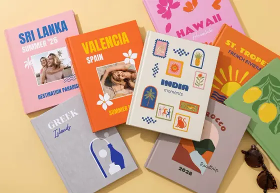 Šareni albumi sa putovanja raspoređeni na stolu